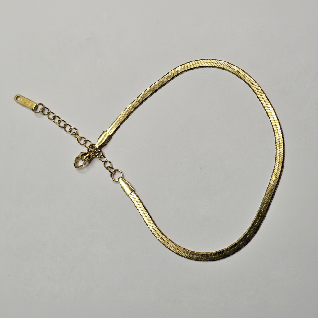 Gold herringbone snake chain bracelet on white background