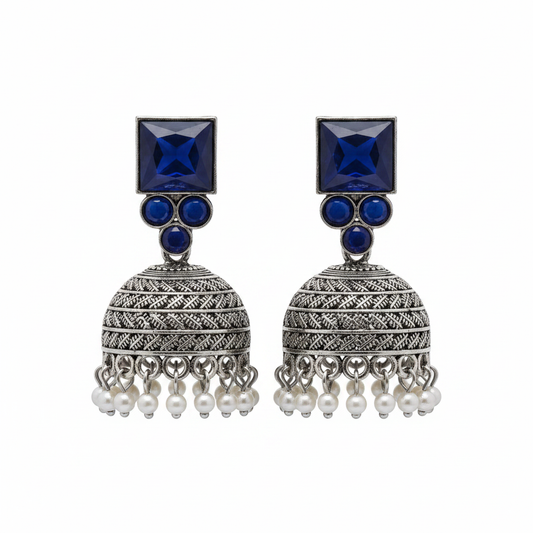 Oxidized silver navy blue sapphire jhumka earrings with pearl drops on white background