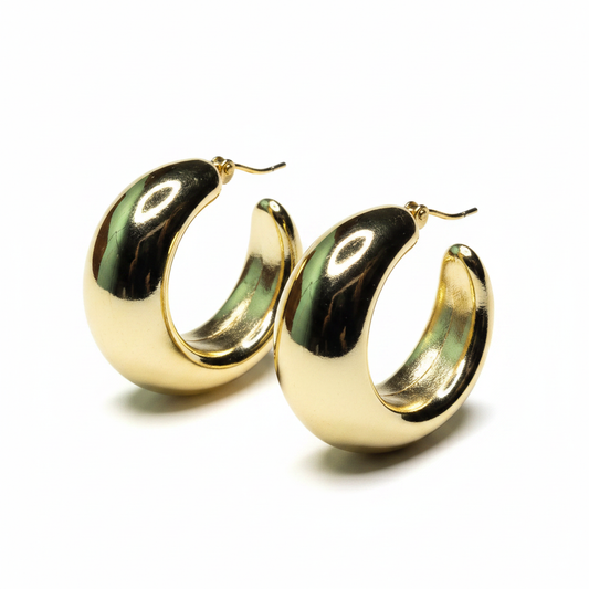 Gold chunky dome hoop earrings with mirror finish on white background