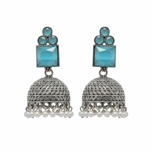 Oxidized silver aqua blue cat eye stone jhumka earrings with pearl drops on white background