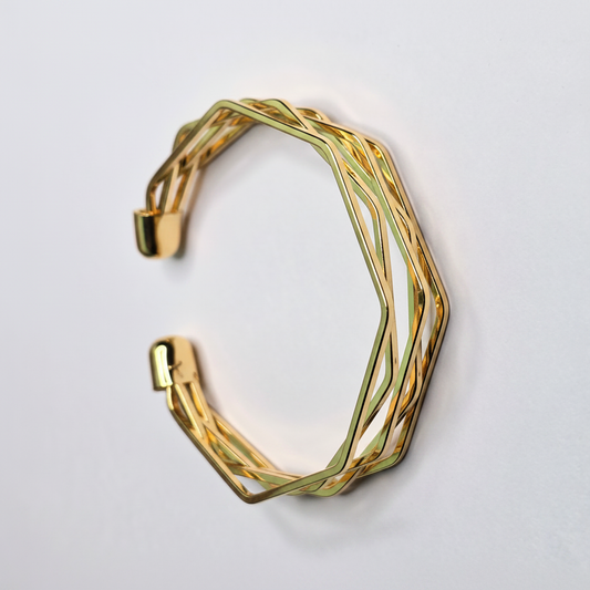 Gold geometric lattice open cuff bangle bracelet on white background